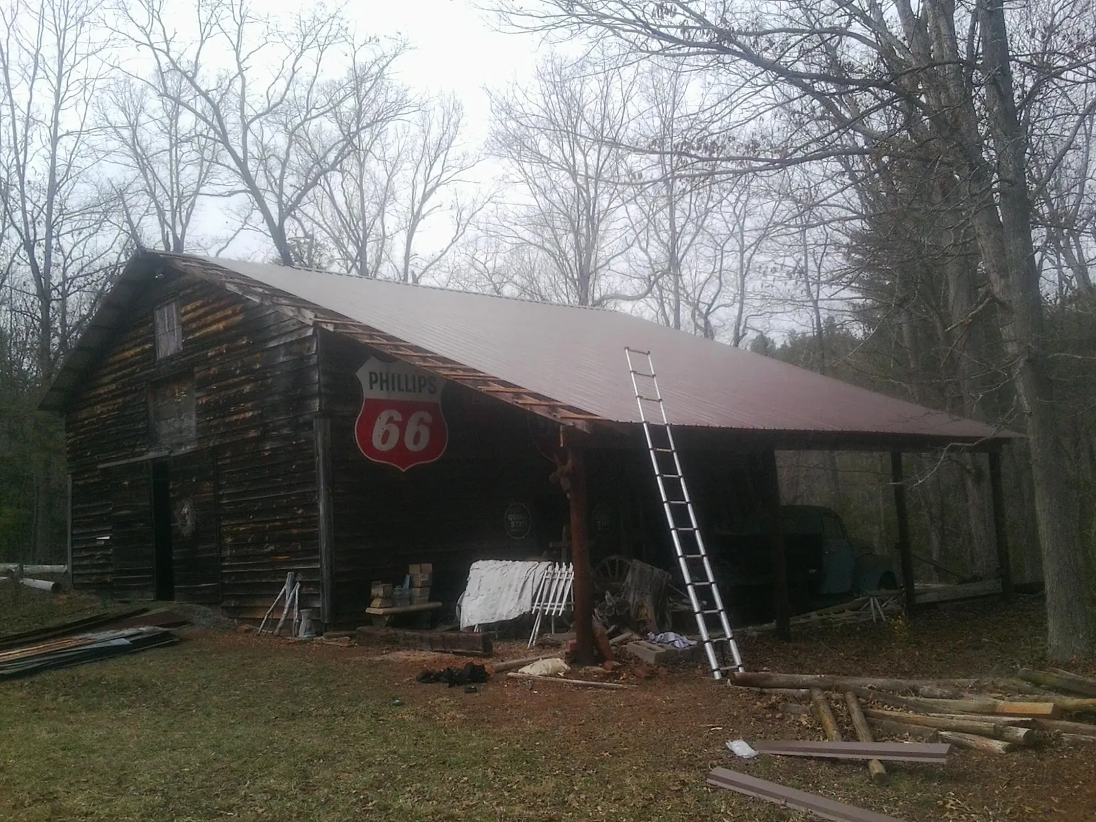 New metal roof on an open sided timber barn with a vintage sign in Glasco