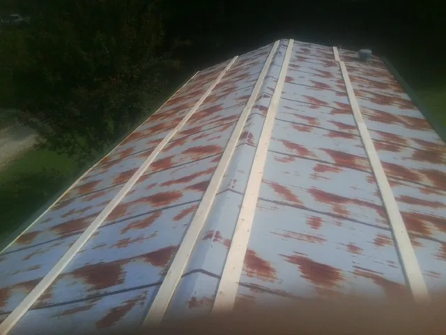 Rusted metal roof panels with new wood purlins before replacement — Storm Damage Roof Repair in Glasco by Roofing Brothers