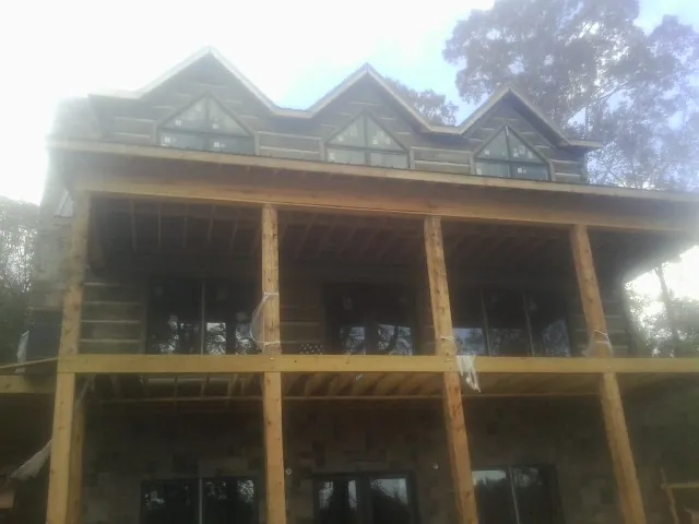 Dormers and porch framing on a large log home under construction — Roof Coating work by our crew in Glasco