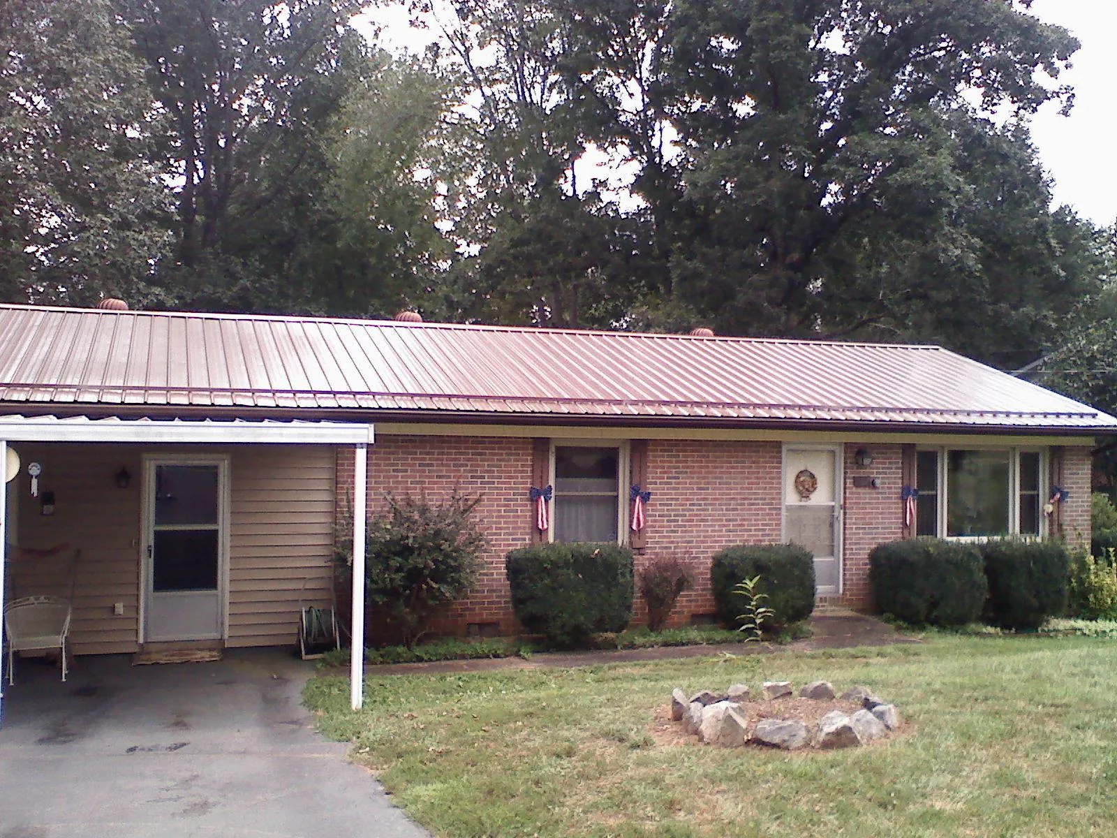 Bronze metal roof and carport on a brick ranch home — Roof Repair work by our crew in Glasco
